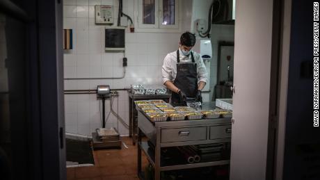 A cook works in Barcelona, ​​Spain on April 16, after his restaurant's kitchen has been converted to prepare food for healthcare professionals and vulnerable people.