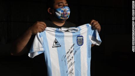 A man holds a replica of the shirt of the Argentine soccer team used during the 1986 World Cup final and signed by Diego Maradona.