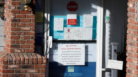 Warning notices have been posted on a door at the entrance to the Cedar Mountain Post Acute nursing facility in Yucaipa, California. There have been 21 resident deaths - the largest number of Covid-19 deaths in any facility in San Bernardino County.
