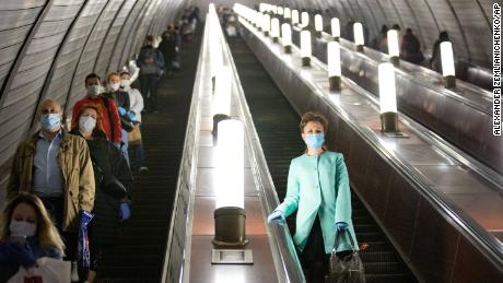 Tuesday, people wearing masks and gloves on an escalator of the metro in Moscow.