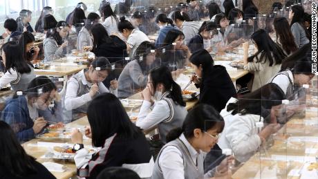 Students have lunch at tables equipped with plastic barriers to prevent the possible spread of the new coronavirus in the cafeteria of the Jeonmin High School in Daejeon, South Korea, Wednesday 20 May.