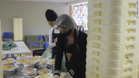 Volunteers prepare some of the 10,000 meals that are delivered to residents of the Paraisopolis favela every day, so they don't need to leave their homes to eat.