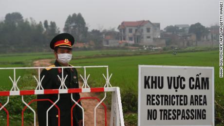 An army officer of a Vietnamese people stands next to a sign warning of the blockade in the city of Son Loi in the province of Vinh Phuc on February 20.