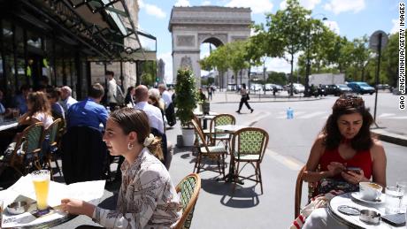 People have lunch at a restaurant near the Arc de Triomphe in Paris, France, on June 18.