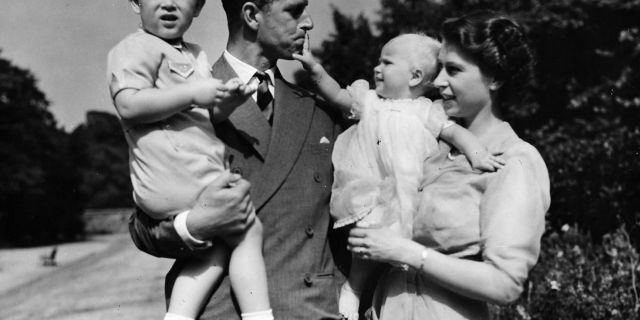 FILE - In this Aug. 1951 file photo, Britain's Queen Elizabeth II, then Princess Elizabeth, stands with her husband Prince Philip, the Duke of Edinburgh, and their children Prince Charles and Princess Anne at Clarence House, the royal couple's London residence. (AP Photo/Eddie Worth, File)