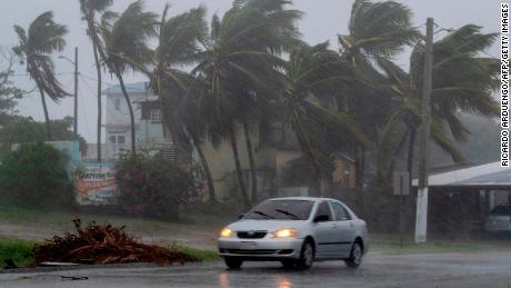 A car drives on a road as Tropical Storm Laura hits Guayama, Puerto Rico.