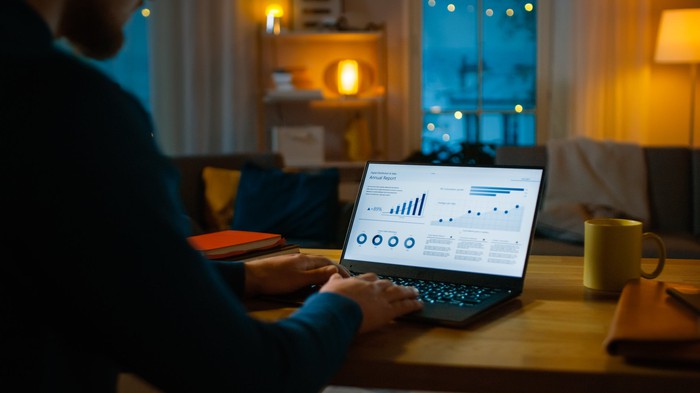 A person looking at charts on a laptop. 