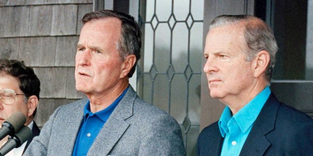Then-Secretary of State James Baker III, right, joins President George H. W. Bush in addressing reporters at Kennebunkport, Maine, Aug. 11, 1990. (Associated Press)