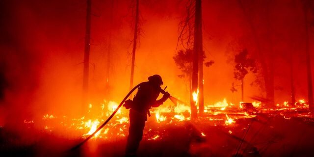 This September 7, 2020, file photo, firefighters will fight creek fires because of the threat to homes in the Cascade Woods neighborhood of Madeira County, Calif.