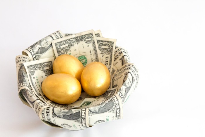 Three golden eggs in a basket with a golden lar bill. 