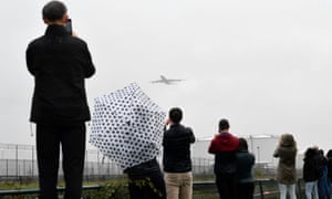 Viewers take photos of one of the departing planes