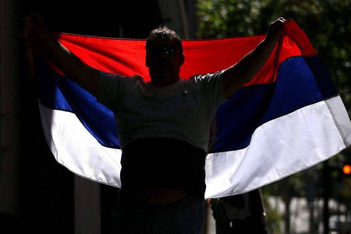     A man with a Serbian flag in front of the office of lawyer Novak Djokovic 1.jpg 