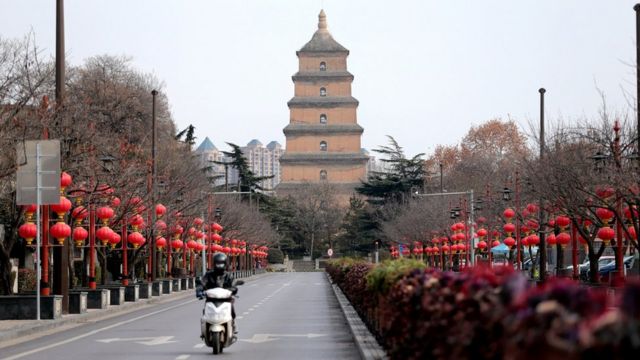 A citizen rides on a nearly empty street after Xi'an imposed a citywide lockdown to curb the spread of the COVID-19 pandemic in Xi'an, Shaanxi province, China December 26, 2021